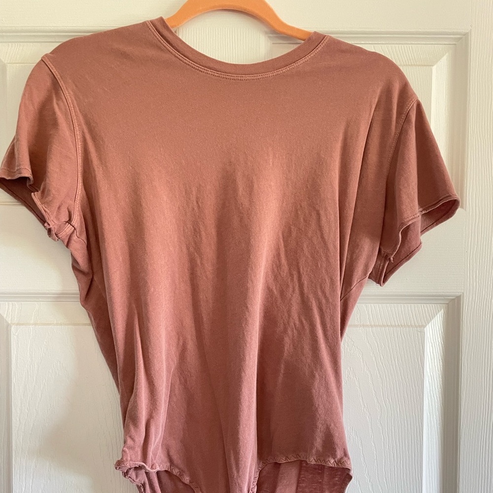 Free people tee body suit in a terracotta color